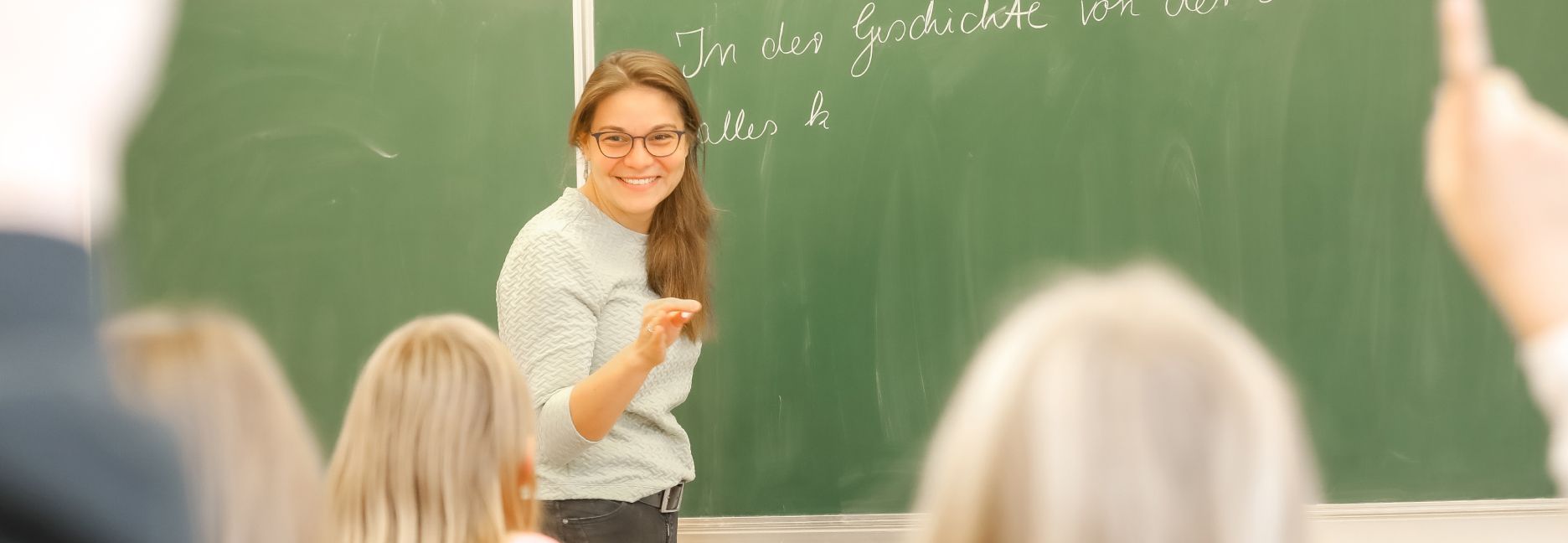 freundliche Lehrerin vor Schulklasse