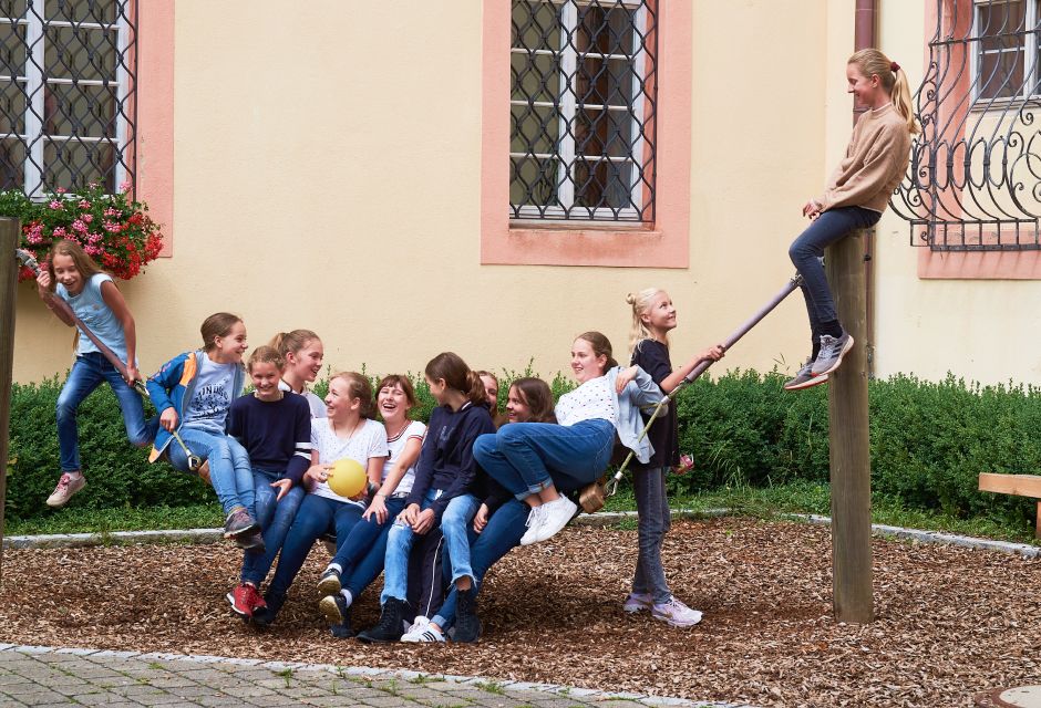 Schülerinnen auf einer Hängematte im Pausenhof